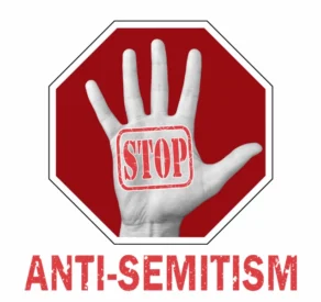 Graphic showing a raised hand with the word 'STOP' stamped on the palm, set against a red stop sign background, with the bold text 'ANTI-SEMITISM' below, symbolizing a message against antisemitism.