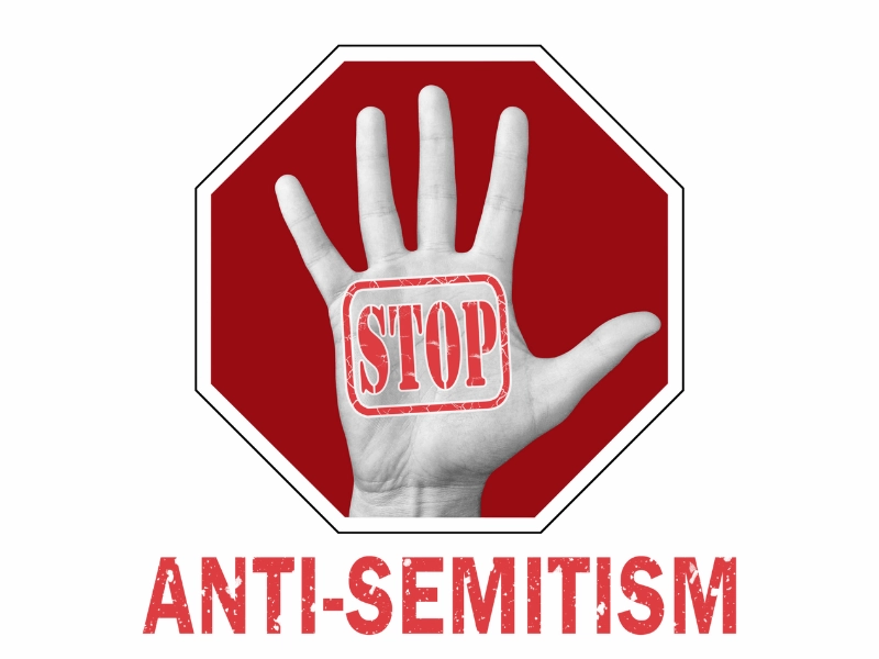 Graphic showing a raised hand with the word 'STOP' stamped on the palm, set against a red stop sign background, with the bold text 'ANTI-SEMITISM' below, symbolizing a message against antisemitism.